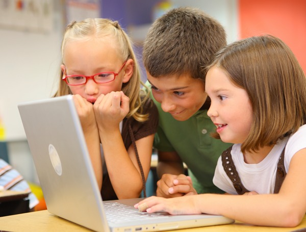 Three pupils looking at a computer screen in class